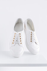 Women's white sneakers on a white background. They levitate. - 441722738