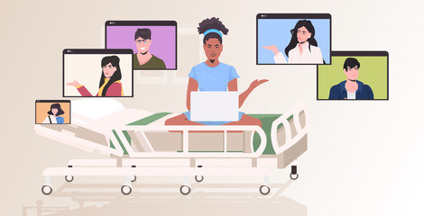 pregnant woman in hospital bed chatting with friends in web browser windows during video call online meeting