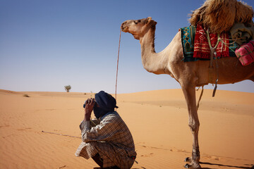 Mauritanian nomad with his camel in the desert of Adrar.