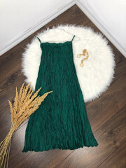 Green silk pleated midi skirt on wooden background