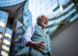 Cheerfully Senior business man walking trough street.