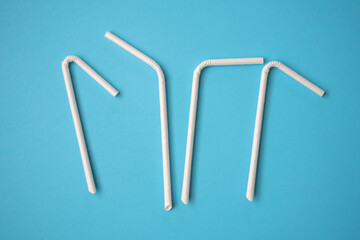 Obraz premium Biodegradable eco friendly white paper drinking straw on blue background