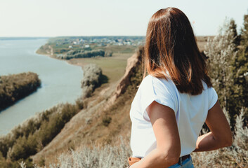 rear view of a young woman looking at autumn river landscape, local travel concept. beautiful and calm and tranquil place. toned photo
