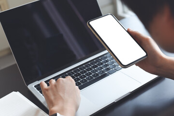 Mockup image of blank white screen mobile phone, business woman using smartphone and working on...