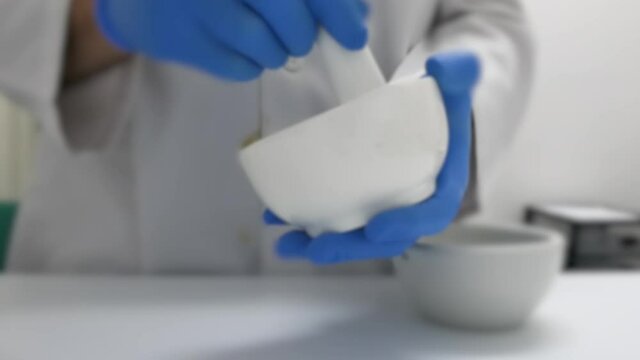 Making an ointment with a mortar in the prescription lab. Initial shot out of focus