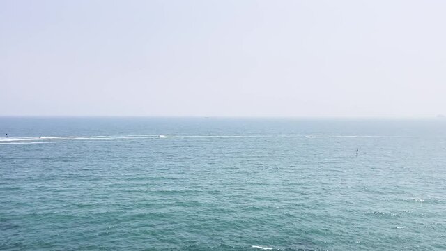 The beautiful blue sea and the big calm waves float in the clear sky.
