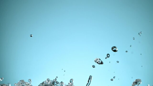 Super slow motion of water splash on light blue background. Filmed on high speed cinema camera, 1000 fps.
