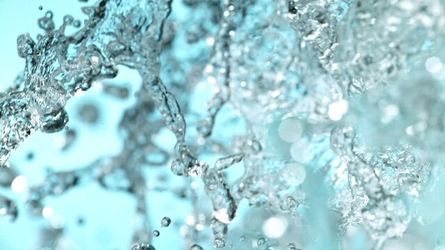 Super slow motion of water splash on light blue background. Filmed on high speed cinema camera, 1000 fps.