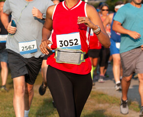 Runner wearing a fuel belt to carry personal items while racing a 5K - obrazy, fototapety, plakaty