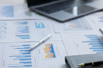 Financial accounting concept with graphs and charts Preparing report.Business reports and pile of documents on gray reflection background. 
