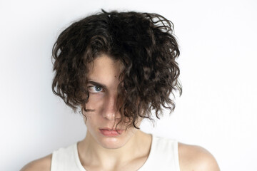 Obraz premium An authentic portrait of a handsome teenager with dark long hair, a young man with a sad look, he looks timidly into the future, he does not know what will happen tomorrow