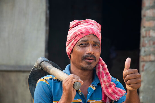 Portrait of a Farmer holding a Shovel showing thumbs up sign