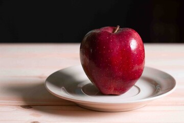 apple in plate on black background.It full of vitamin.