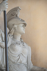 Naklejka premium Old statue of a sensual Roman woman warrior, Amazonian, as defender with spear and helmet, details, closeup, with copy space.