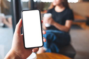 Mockup image of a man holding mobile phone with blank white screen with a woman in background