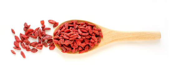 Dry organic goji berry seed pile in wooden spoon on white background