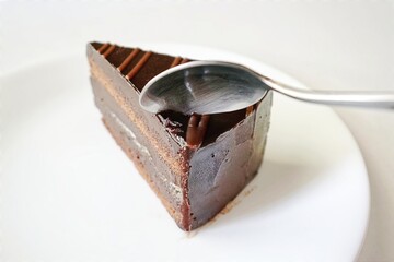 Spoon cutting piece chocolate cake. 