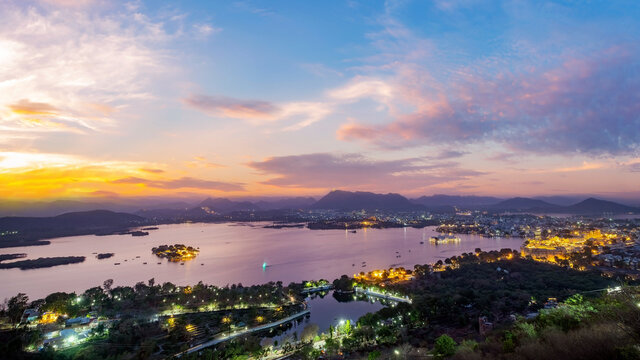Udaipur city at lake Pichola in the evening, Rajasthan, India. View from  the mountain viewpoint see the whole city reflected on the lake.