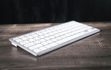 White computer keyboard on wooden table.