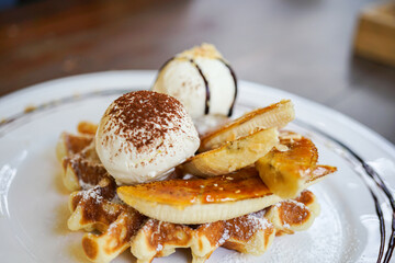 Fresh waffles with ice cream and maple syrup on a wooden background, Food and Dessert background concept