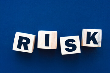 inscription RISK on wooden cubes on a blue background