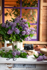 Bouquet of lilacs in a vintage basket. Beautiful violet Lilac flower still life Easter border design on wooden table.