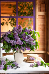 Fototapeta na wymiar Bouquet of lilacs in a vintage basket. Beautiful violet Lilac flower still life Easter border design on wooden table.