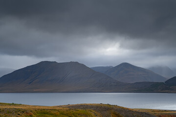 West Fjords or The Westfjords is region in north Iceland. Dramatic moody sky nature landscape. Low clouds on mountains