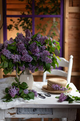 Bouquet of lilacs in a vintage basket. Beautiful violet Lilac flower still life Easter border design on wooden table.