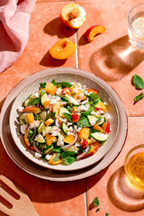 Summer peach and cheese salad on tile table, top view