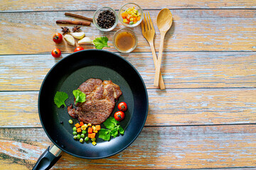 pork steak in pan,Grilled pork steak in frying pan over dark background, top view