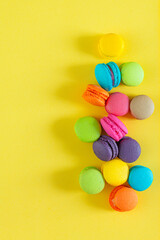 Macaroons,sweet colored macaroons in a box on a yellow background, space for text, top view