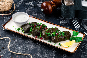 Dolma. Stuffed grape leaves with meat on dark table. Middle eastern cuisine