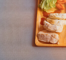 Top view of chicken boiled with vegetables served on wooden plate on  gray cloth background