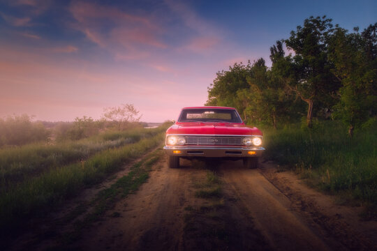Engels, Russia - May 26, 2021: Retro red muscle car Chevrolet Malibu Chevelle SS is parked on countryside road at golden sunset