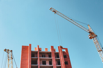 Construction of a new brick house with a tower crane.