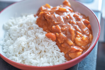 Home cooked king prawn curry on a bed of freshly steamed basmati rice with intentional seelctive focus, shallow depth of field and bokeh