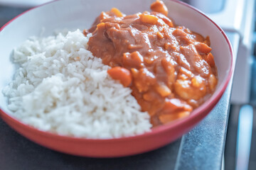 Home cooked king prawn curry on a bed of freshly steamed basmati rice with intentional seelctive focus, shallow depth of field and bokeh