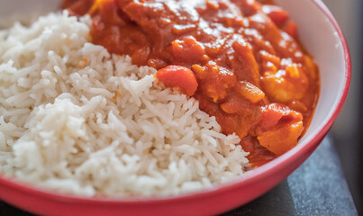 Home cooked king prawn curry on a bed of freshly steamed basmati rice with intentional seelctive focus, shallow depth of field and bokeh