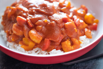 Home cooked king prawn curry on a bed of freshly steamed basmati rice with intentional seelctive focus, shallow depth of field and bokeh