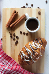 A cup of aromatic black coffee and coffee beans on the table with cinnamon sticks. Morning espresso...