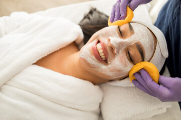 Mujer mexicana felizmente  relajada tomando un tratamiento de cuidado exfoliante de piel