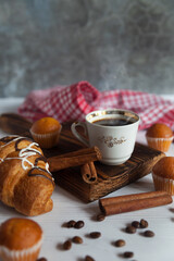A cup of aromatic black coffee and coffee beans on the table with cinnamon sticks. Morning espresso...