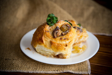 Sweet curled bun with jam, raisins in powdered sugar