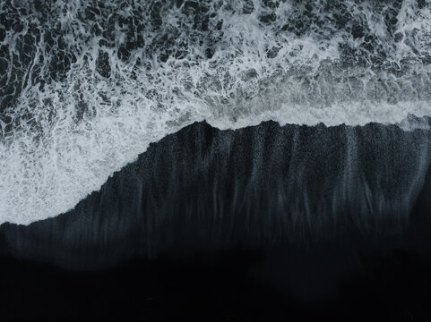 Abstract nature background. Aerial drone view of black sand beach and ocean waves in South Iceland
