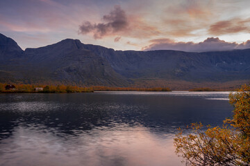 Colorful beautiful pink  sunset on a  mountain lake  in autumn with reflections in the water behind Arctic circle, Kola Peninsula, Khibiny Mountains
