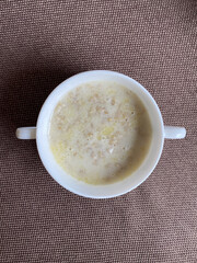 white plate with oatmeal on the table top view
