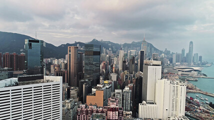 Top view aerial photo from flying drone of a developed Hong Kong city with modern skyscrapers with contemporary design. China town with business and financial centers and road with cars