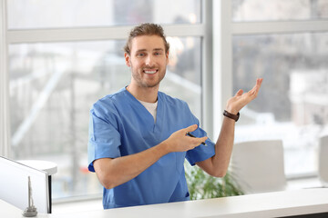 Male receptionist showing something in clinic