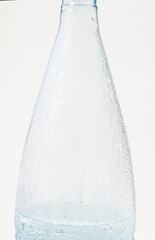 Vertical closeup of plastic bottle with condensation water droplets